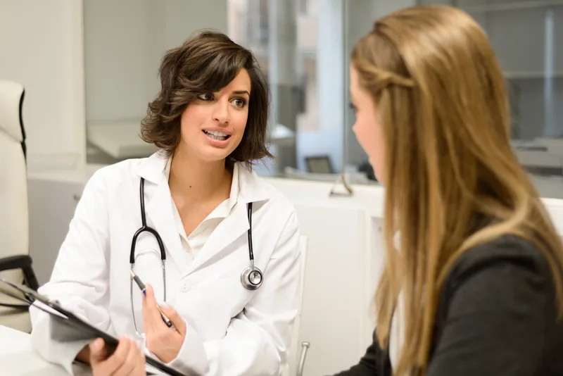 Médecin femme à l’écoute d’une patiente qui décrit une brûlure dans le sein