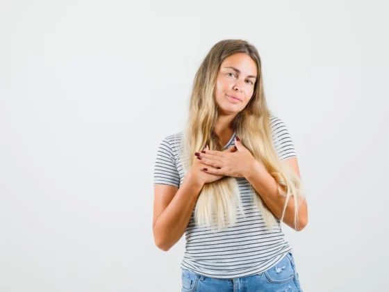 Femme posant les mains sur sa poitrine, gênée par une douleur au sein droit