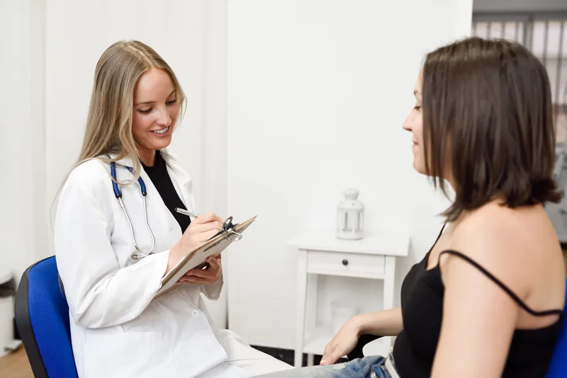 Médecin femme échangeant avec une patiente lors d’une consultation pour une douleur au sein